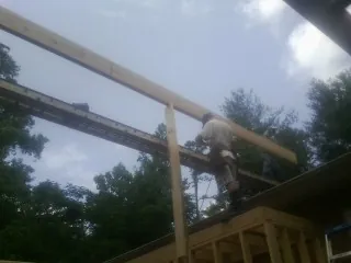 Carpenter setting a ridge beam over a new addition frame — Ice Dam Removal by Roofing Brothers in Rhinelander