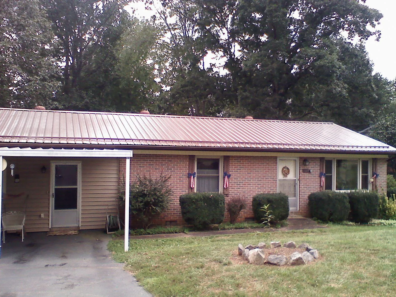 Bronze metal roof and carport on a brick ranch home — Roof Repair work by our crew in Rhinelander