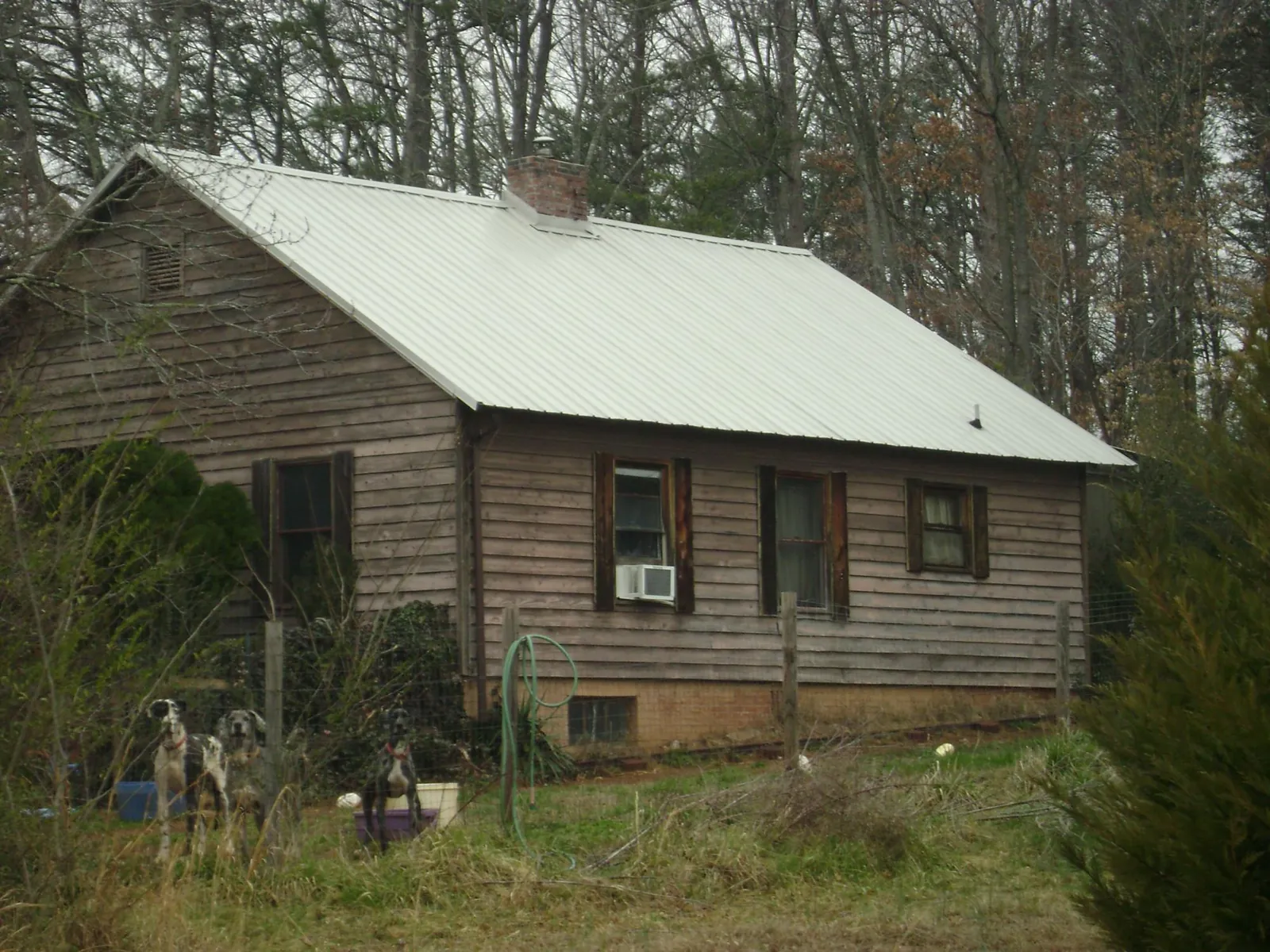 White metal roof on an old wood sided farmhouse, from a Metal Roof Installation job in Rhinelander